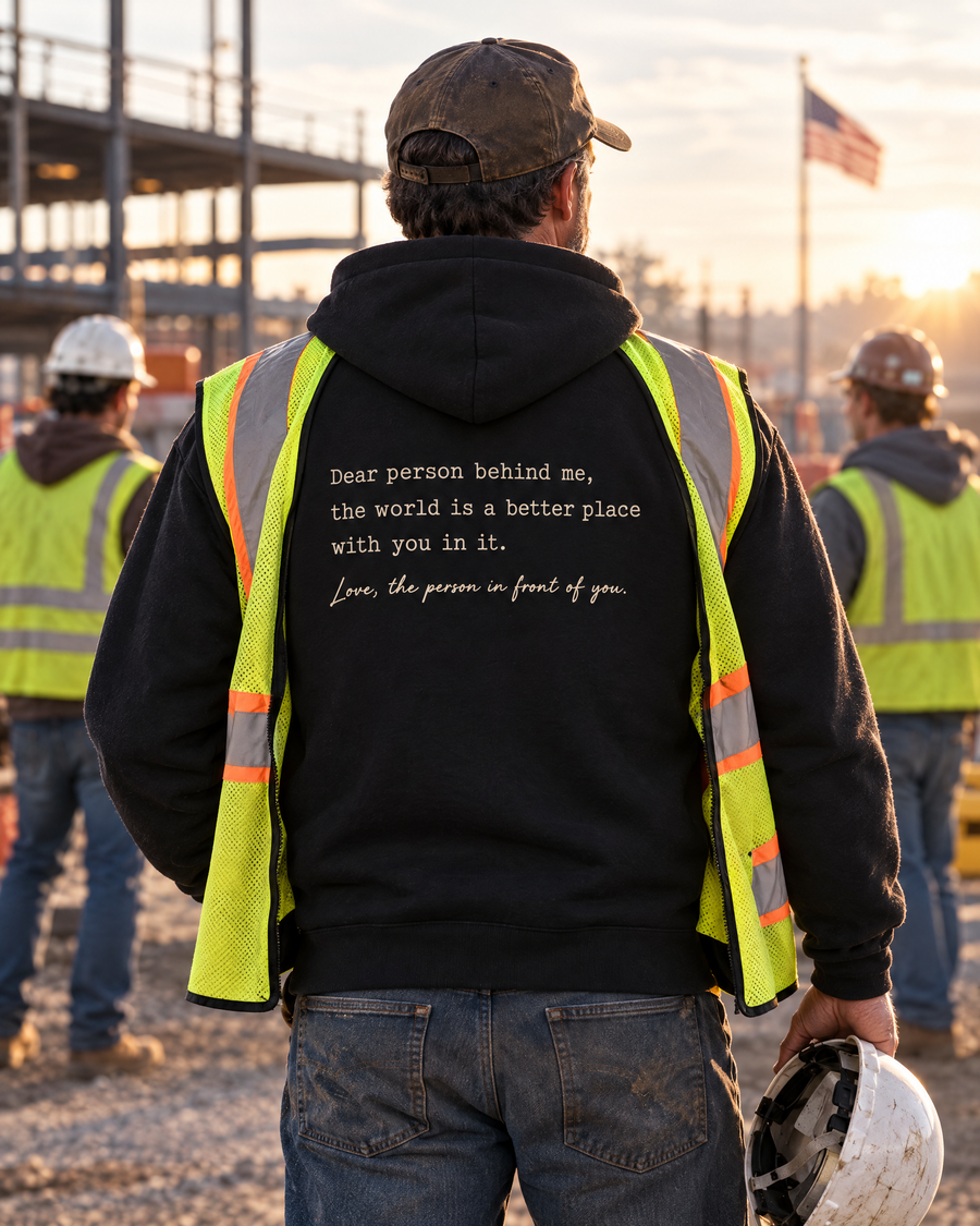 A construction worker wearing the black message hoodie at a job site